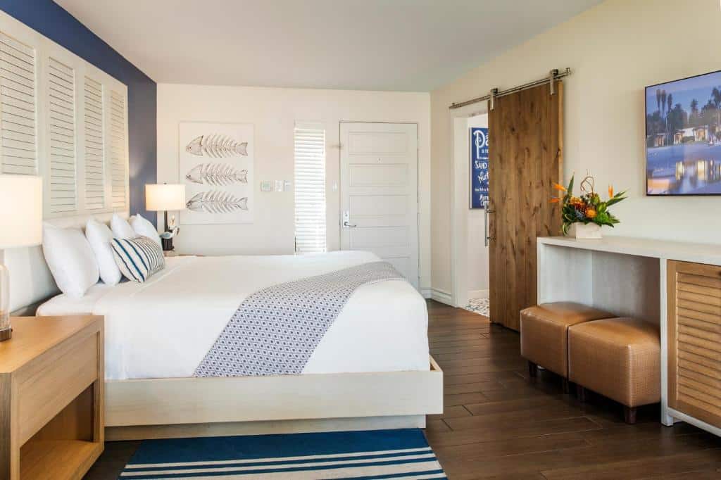 Quarto do Paradise Point Resort & Spa com cama de casal, duas cômodas ao lado da cama com luminária, TV em frente a cama. Representa hotéis em San Diego