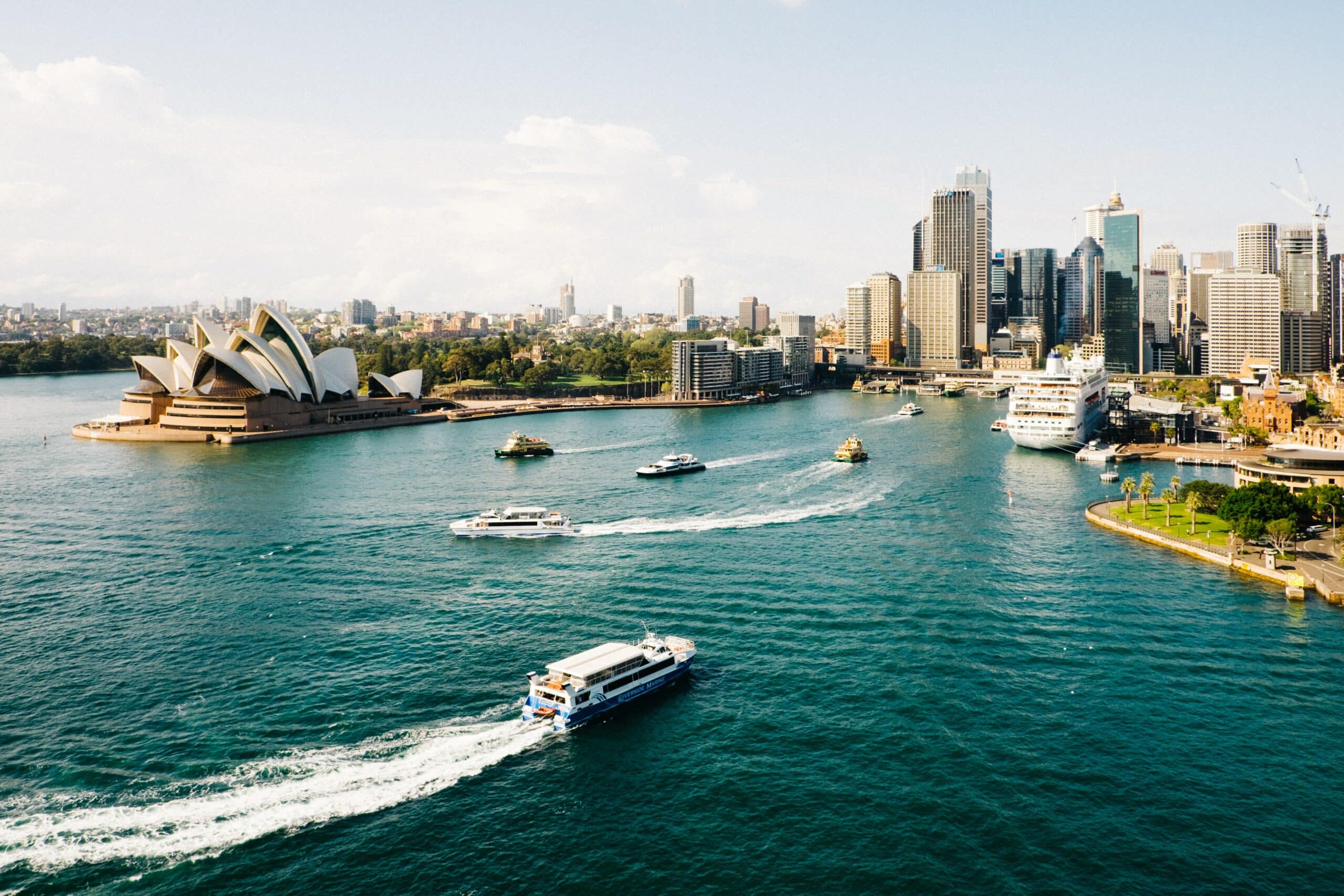 Vista da cidade Sydney, Austrália com barcos ao mar e cidade ao fundo cheia de prédios altos. Representa chip celular Austrália