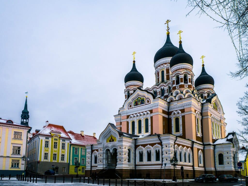 vista de uma catedral e algumas casinhas coloridas ao estilo soviético, com cores pastéis vivas em Talín, capital da Estônia, que ilustra o post de chip celular Leste Europeu