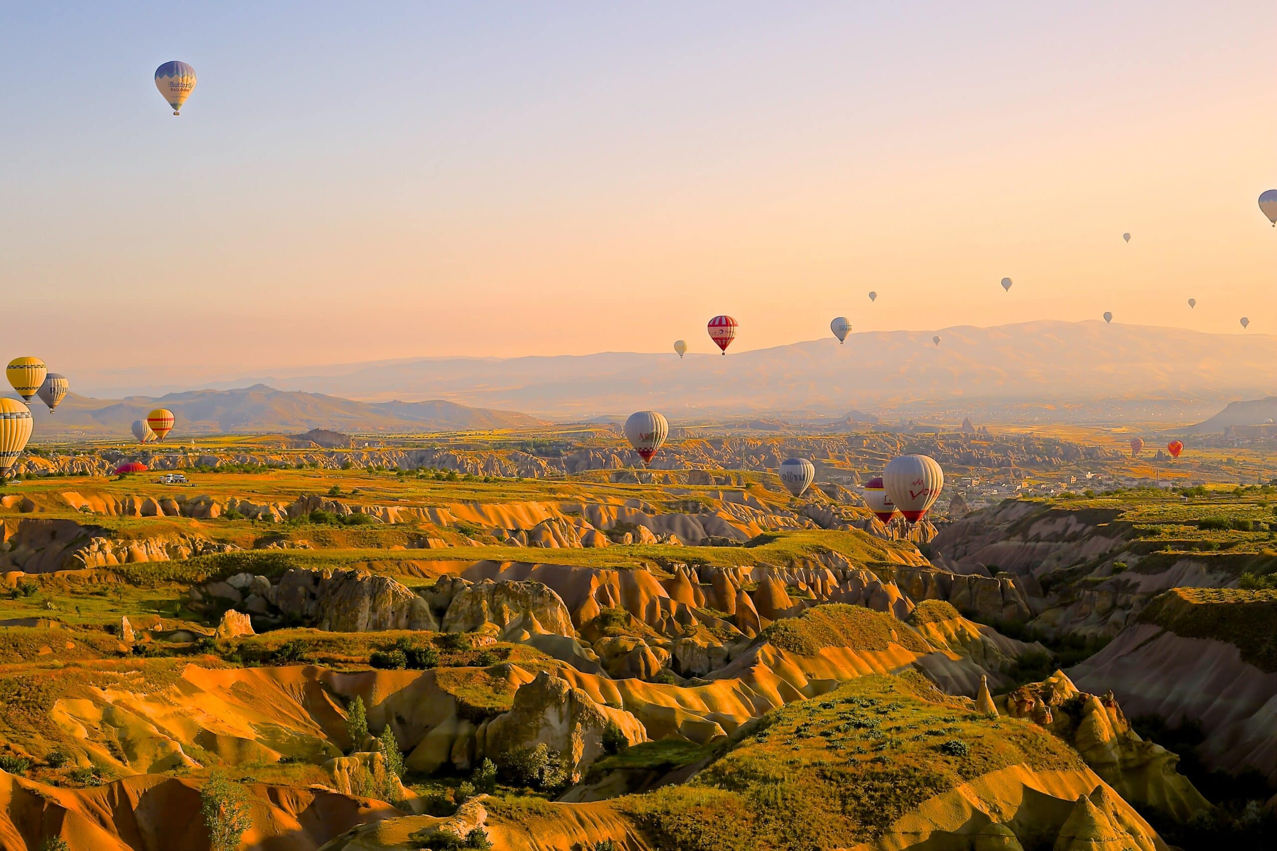 Vista do vale de Capadócia, Turquia, no final do dia com vários balões no céu. Representa chip celular Turquia.