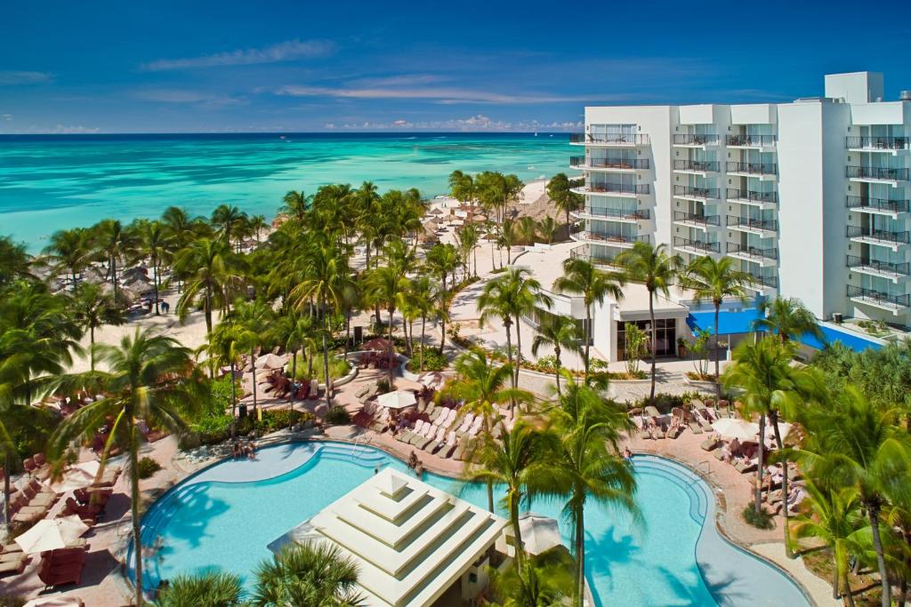 vista aérea do Aruba Marriott Resort & Stellaris Casino com diversas palmeiras ao redor da piscina e vista panorâmica do mar azul turquesa