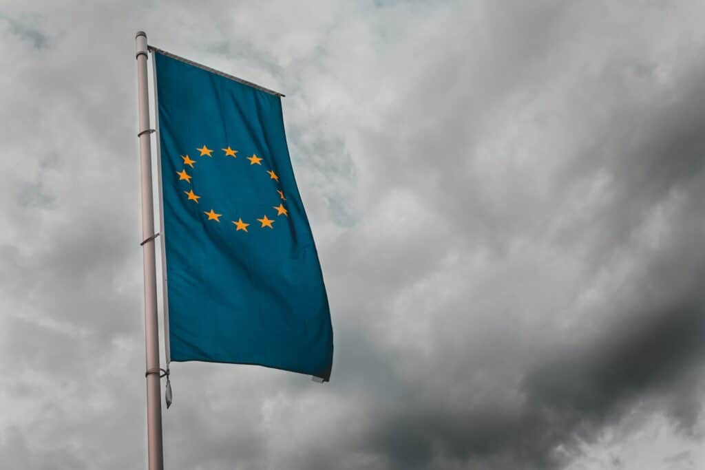 Bandeira da União Europeia, azul escura com uma coroa de estrelas, estiada na cidade de Schwäbisch Gmünd, na Alemanha, em um dia de céu carregado, cheio de nuvens escuras
