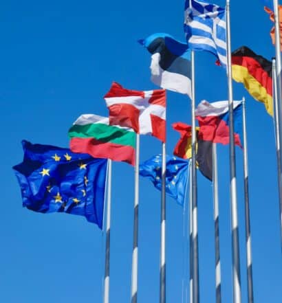 Bandeiras da UE e de países europeus no Parlamento Europeu, na cidade de Strasbourg, na França, em um dia de céu azul intenso e sem nuvens, ilustrando o post sobre o ETIAS