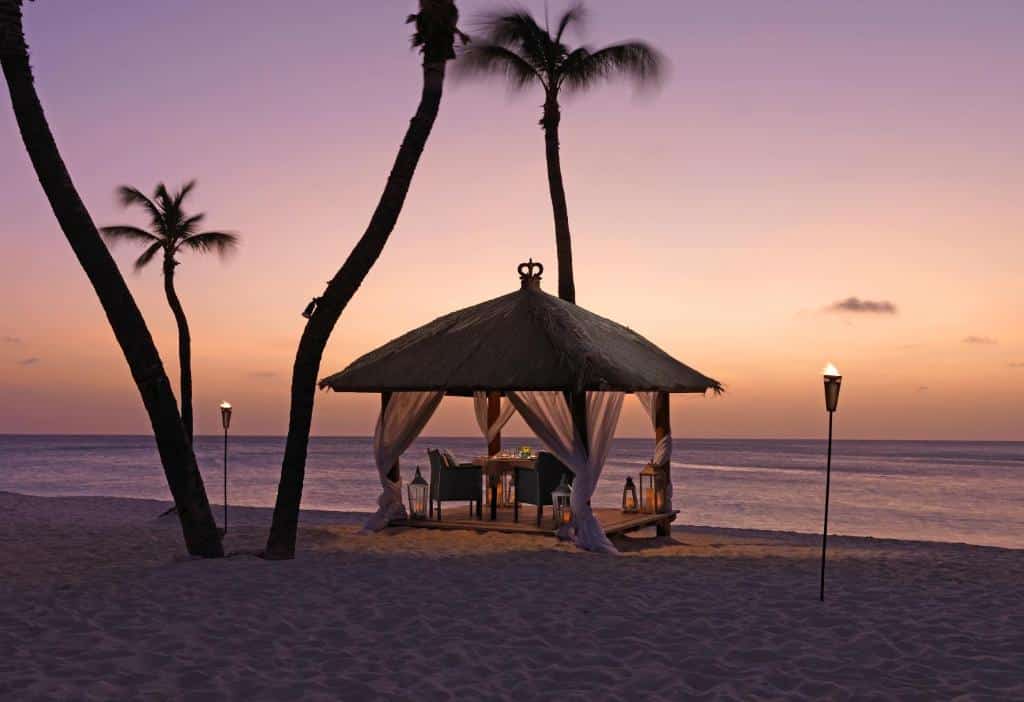 pôr do sol na praia do Bucuti & Tara Boutique Beach Resort com uma mesa particular para duas pessoas
