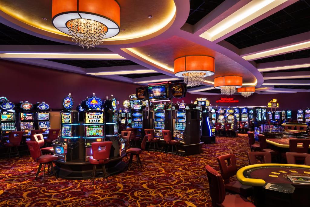 cassino do The Ritz-Carlton, Aruba com vários caça-níqueis e mesas de pôquer espalhadas pelo salão bem iluminado e estilizado