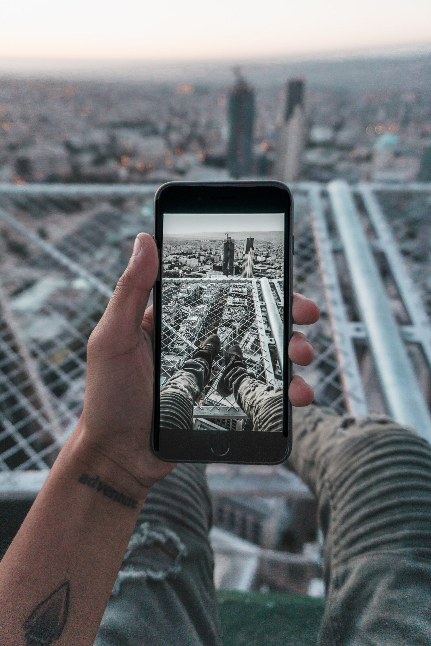 Homem sentado na cobertura do telhado em Amman, Jordânia tirando foto dos pés. Representa chip celular Jordânia
