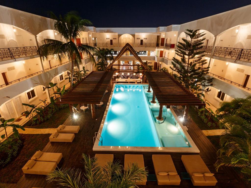 Piscina do HM Playa del Carmen com um extenso deck de madeira ao redor com áreas cobertas e algumas espreguiçadeiras, para representar hotéis em Playa del Carmen