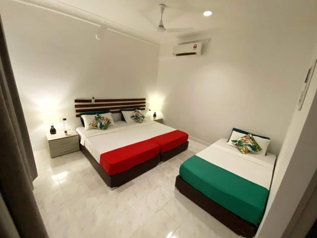 Quarto do Ocean Breeze Maldives, de 30 m², com uma cama de casal e uma de solteiro, ar-condicionado e ventilador de teto