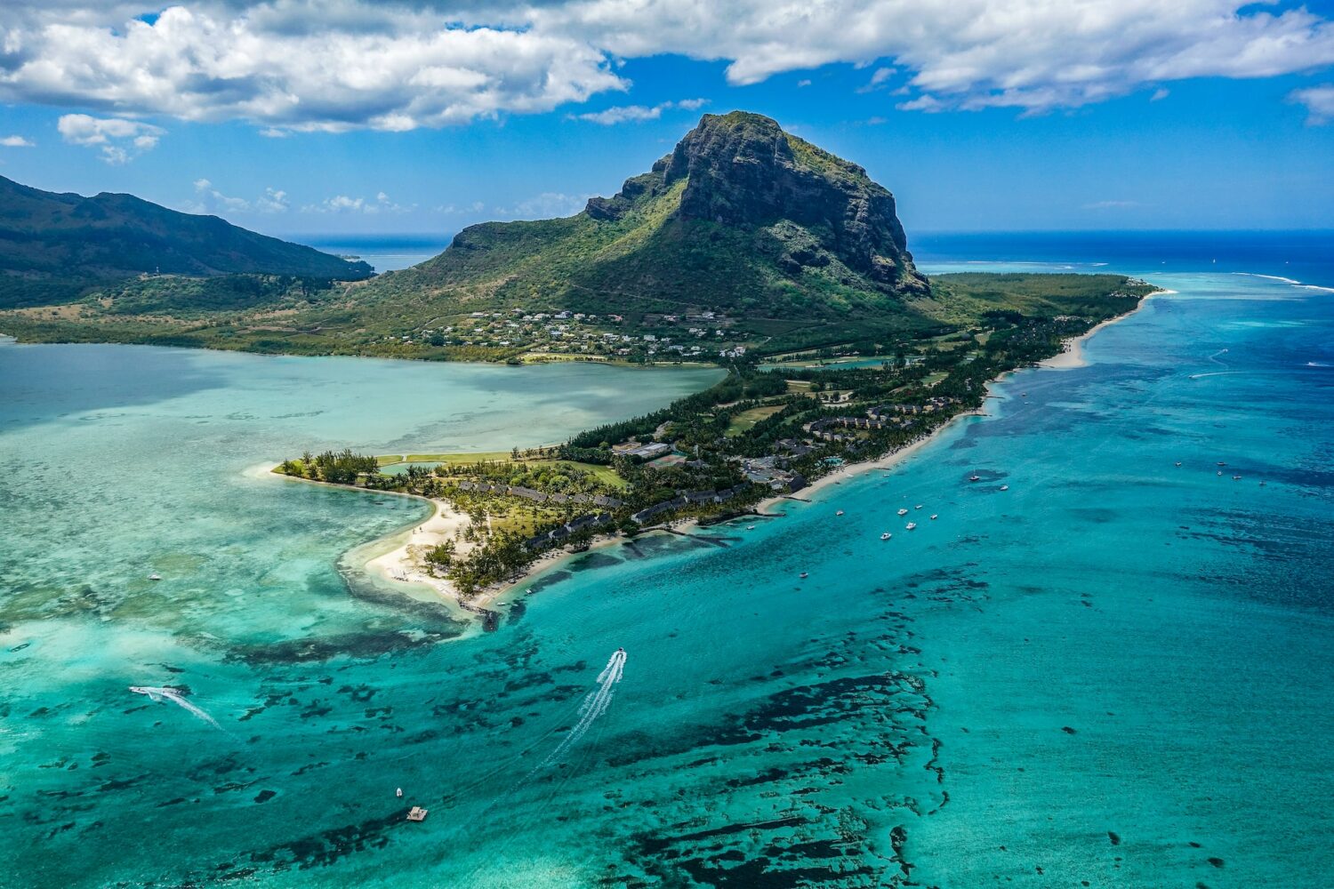 Fotografia aérea da ilha em tons de verde em volta do mar azul durante o dia, ilustrando post seguro viagem Ilhas Maurício.