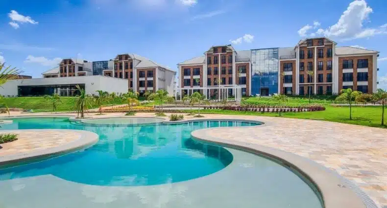 Vista da piscina do Royal Tulip Holambra durante o dia com o hotel ao fundo. Representa hotéis em Holambra