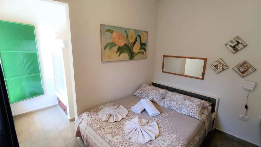 Quarto do Chalés Vila da Serra com cama de casal, toalhas em cima da cama.