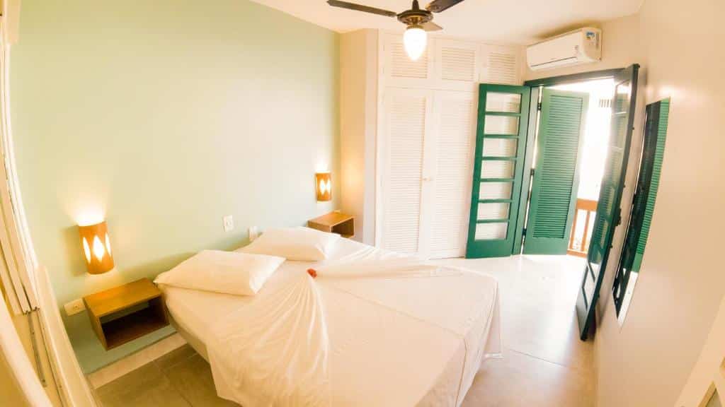 Quarto do Porto Paúba com cama de casal, duas cômodas de madeira e do lado esquerdo uma porta de madeira verde que dá acesso a varanda.