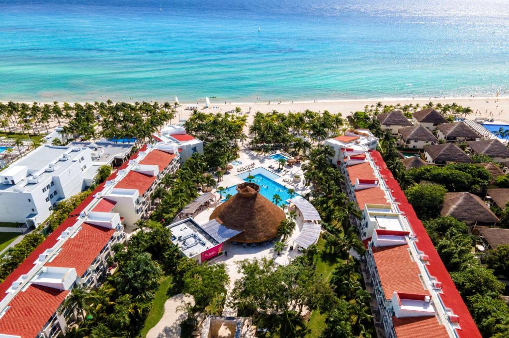 Vista aérea do Viva Wyndham Azteca All Inclusive sendo possível enxergar as piscinas do hotel e todo o espaço verde  da hospedagem que está de frente para a praia