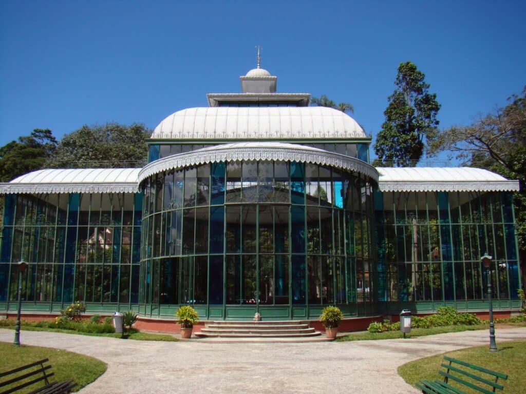 Um palácio inteiro de vidro cercado por um jardim