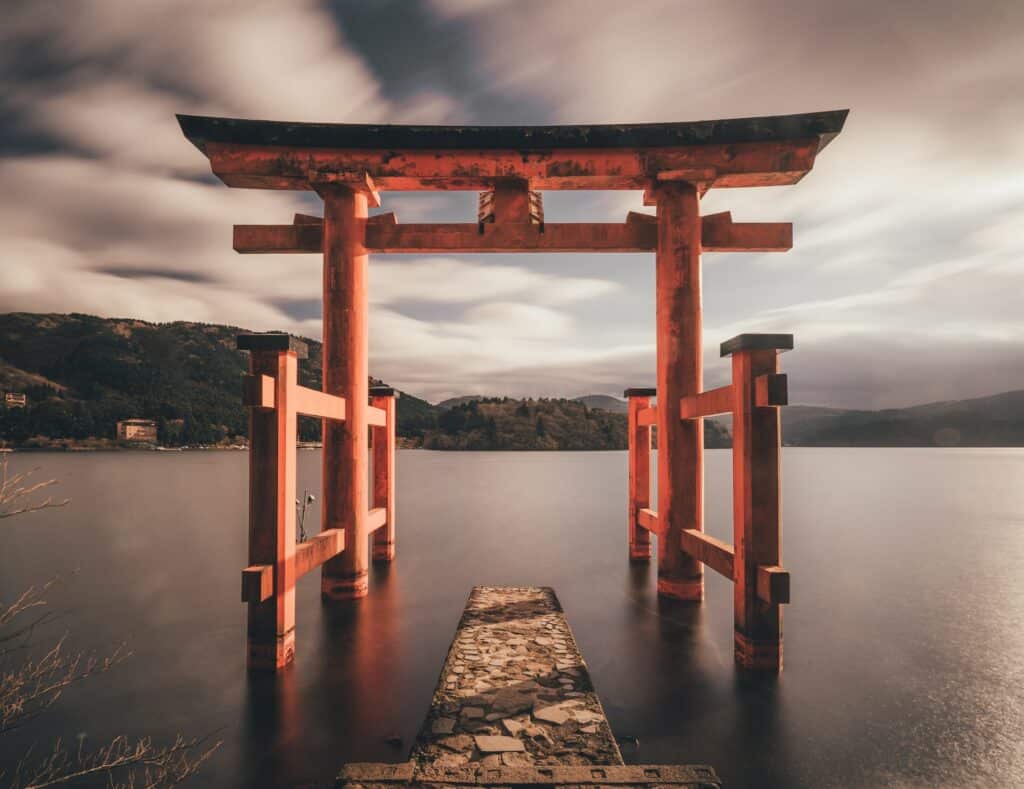 vista de um portal, acima da água límpida e calma, a estrutura é característica, em Templo Hakone, em Hakone, para ilustrar o post de chip celular Japão