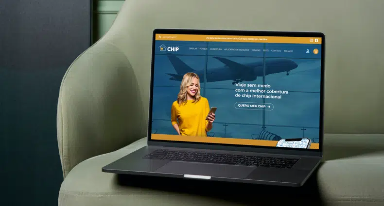 notebook aberto em cima de uma poltrona bege. A tela mostra a home oficial do site A Casa do Chip