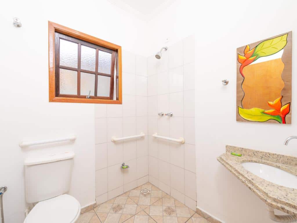 Banheiro com acessibilidade no Vistabela Resort & Spa com barras de segurança no chuveiro e perto do vaso sanitário e pia baixa.