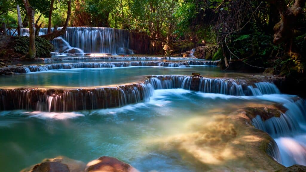 Cachoeiras de Kuang Si, com quedas d'água em várias alturas, água cristalina e bastante natureza em volta