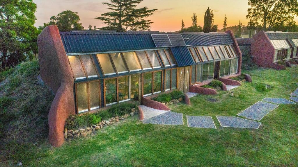 Pequenas casas de vidro do Caliu Earthship Ecolodge com um jardim na frente e muita natureza ao redor da propriedade, para representar hotéis em Colonia del Sacramento