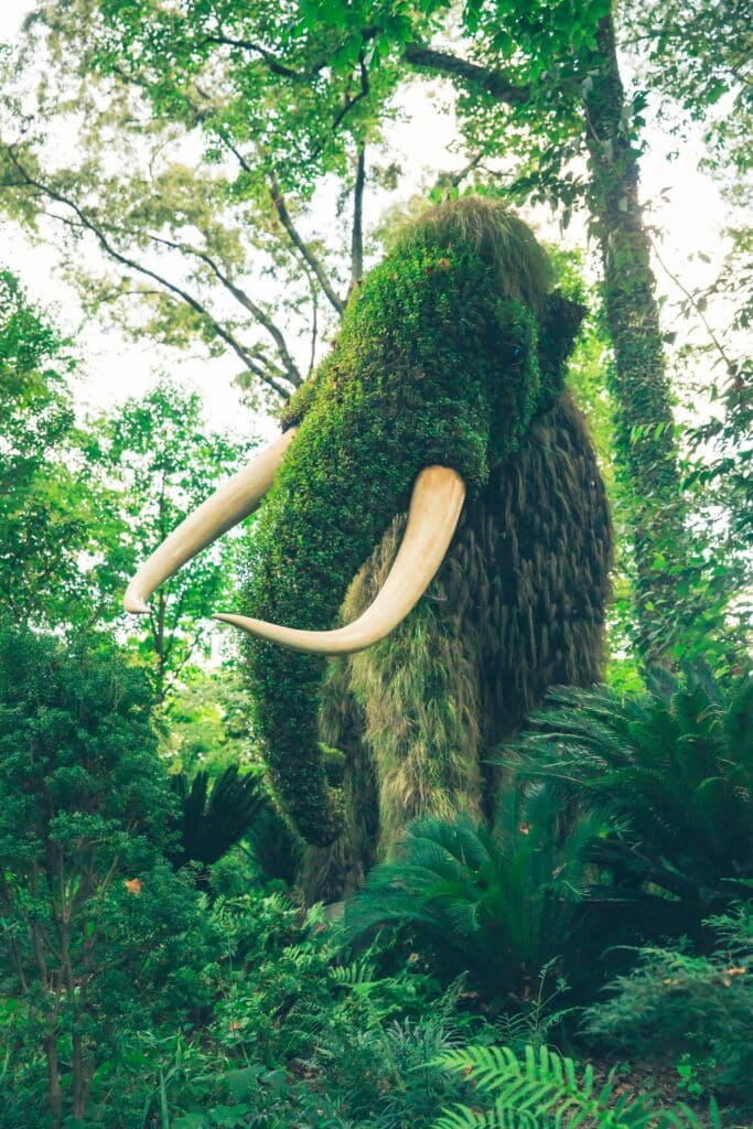 Escultura de plantas em formato de mamute para ilustrar o post sobre chip de celular para Atlanta. Há diversas árvores ao redor. - Foto: Christopher Alvarenga via Unsplash