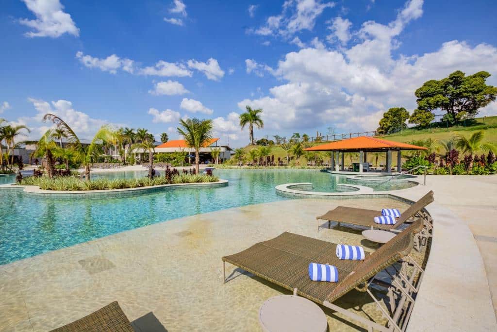 Piscina bem ampla do Cyan Resort by Atlantica com espreguiçadeiras de frente para a piscina e, ao redor da propriedade, há muito verde