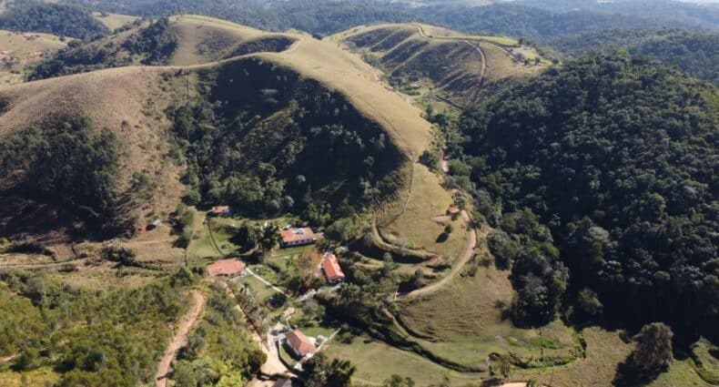 Vista aérea do Espaço Rural Água da Onça, uma das pousadas em Guararema, com montanhas e bastante natureza em volta das casas da acomodação