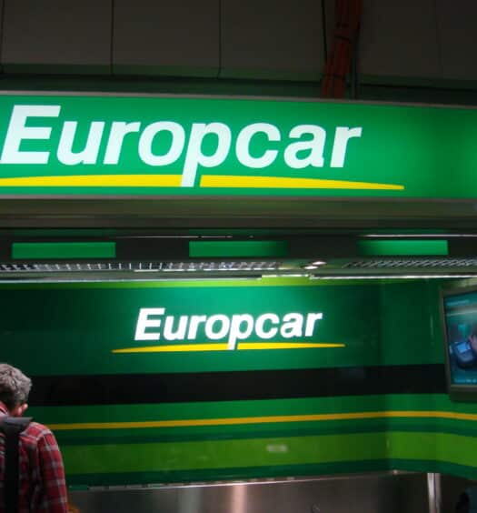 Logos da Europcar, com fundo verde, letras brancas e sublinhado amarelo, ilustrando o post sobre a locadora Europcar Rent a Car