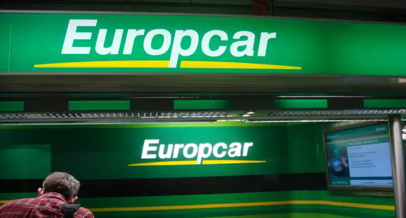 Logos da Europcar, com fundo verde, letras brancas e sublinhado amarelo, ilustrando o post sobre a locadora Europcar Rent a Car