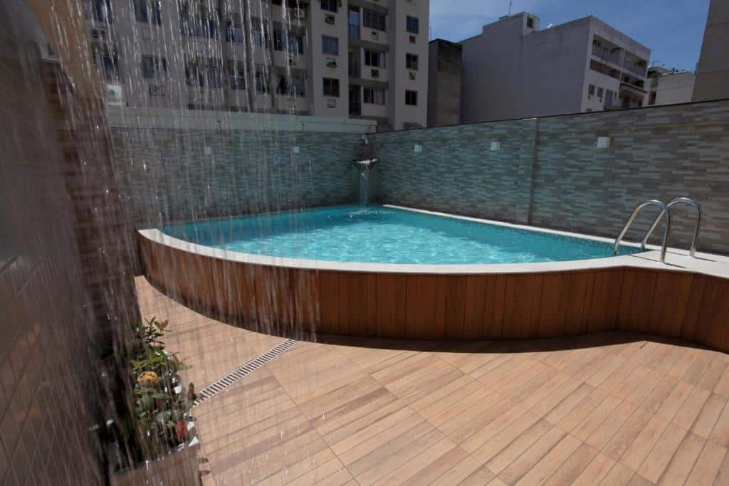 Piscina do Fluminense Hotel com um pequena deck ao redor e uma ducha na lateral esquerda