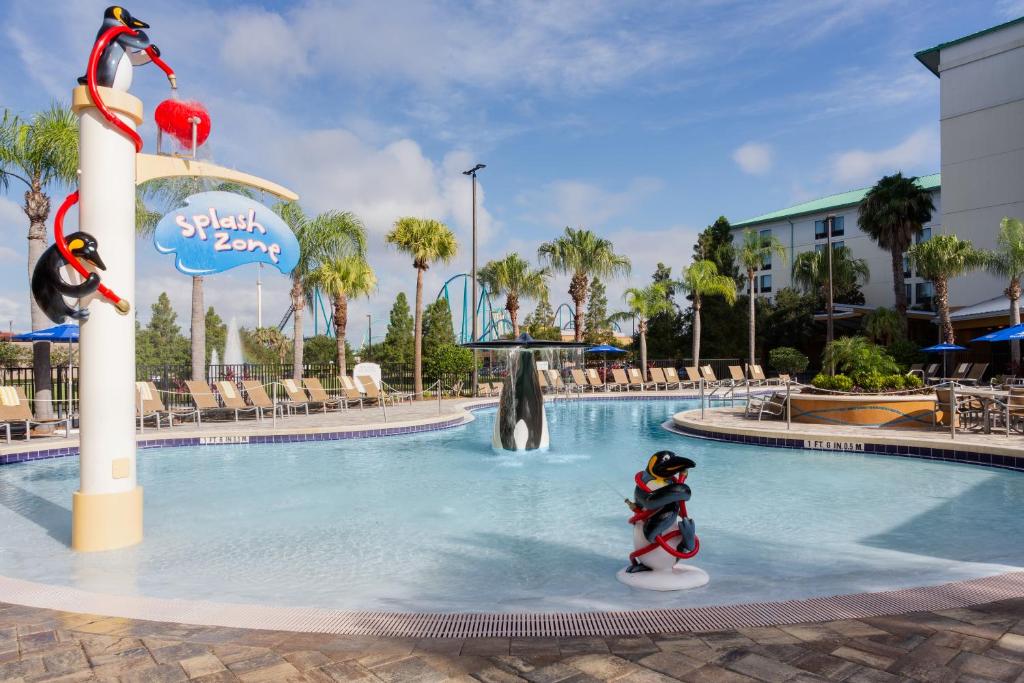 Piscina do Fairfield Inn Suites by Marriott Orlando At SeaWorld com alguns pinguins de brinquedo que soltam água dentro da piscina