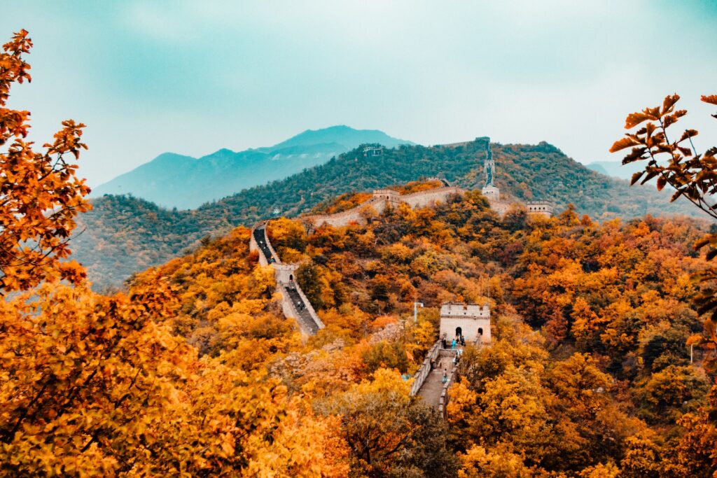 vista da Grande Muralha da China, com uma vegetação amarelada e a grande muralha em que há pessoas feitas em pedra incrustradas na floresta com céu azul ao fundo, para ilustrar o post de chip celular Ásia