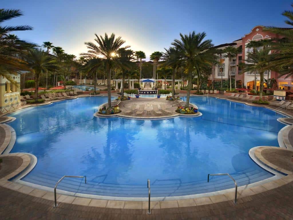 Piscina ampla do Marriott's Grande Vista com um bangalô com bar no centro da piscina, o deck é cercado por palmeiras e espreguiçadeiras