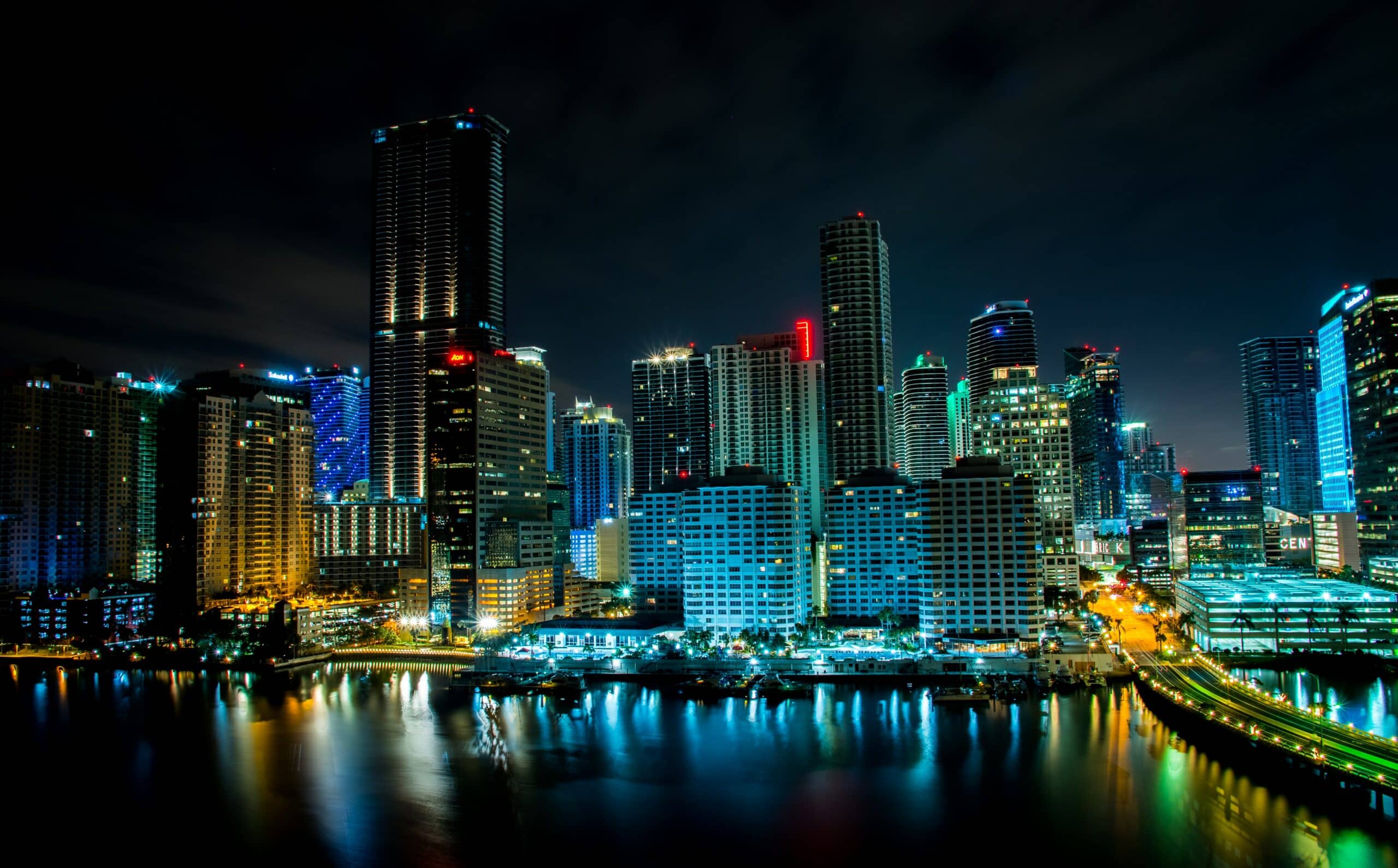 Vista da cidade de Miami à noite com vários prédios iluminados.