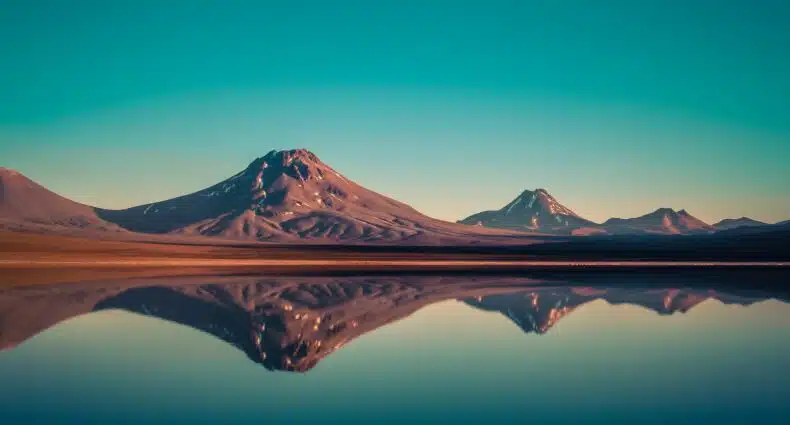 Vista da Laguna Lejía, San Pedro de Atacama durante o dia com montanhas ao fundo do lago. Representa chip celular Atacama.