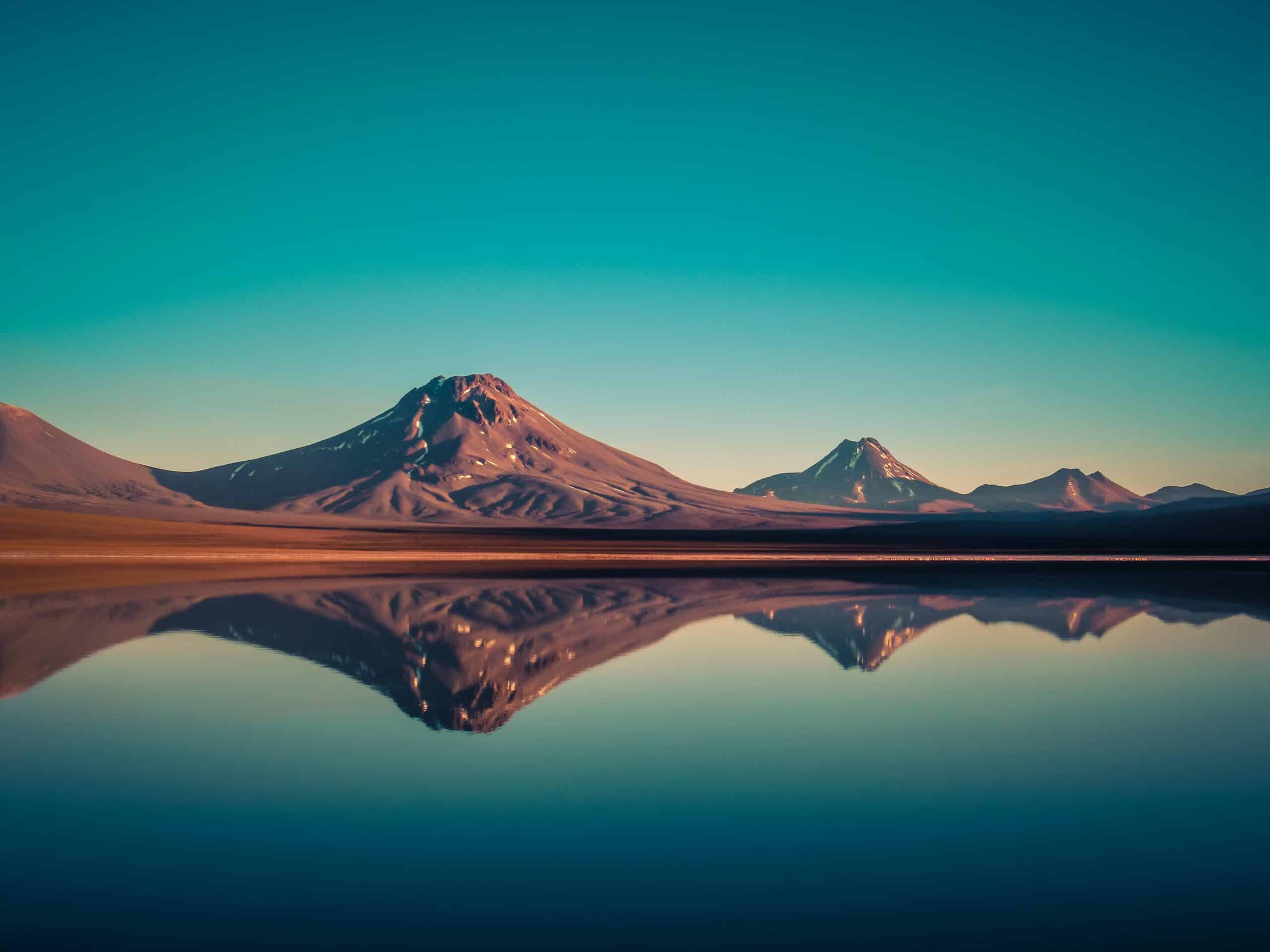 Vista da Laguna Lejía, San Pedro de Atacama durante o dia com montanhas ao fundo do lago. Representa chip celular Atacama.