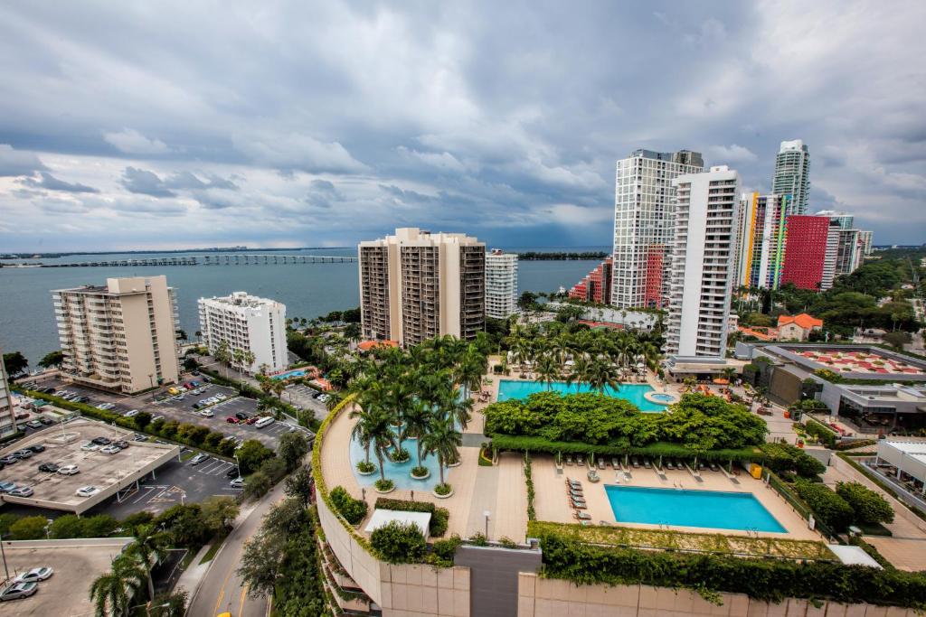 Vista da piscina de cima do  Fortune House Hotel Suites  durante o dia com prédios em volta. Representa hotéis em Miami.