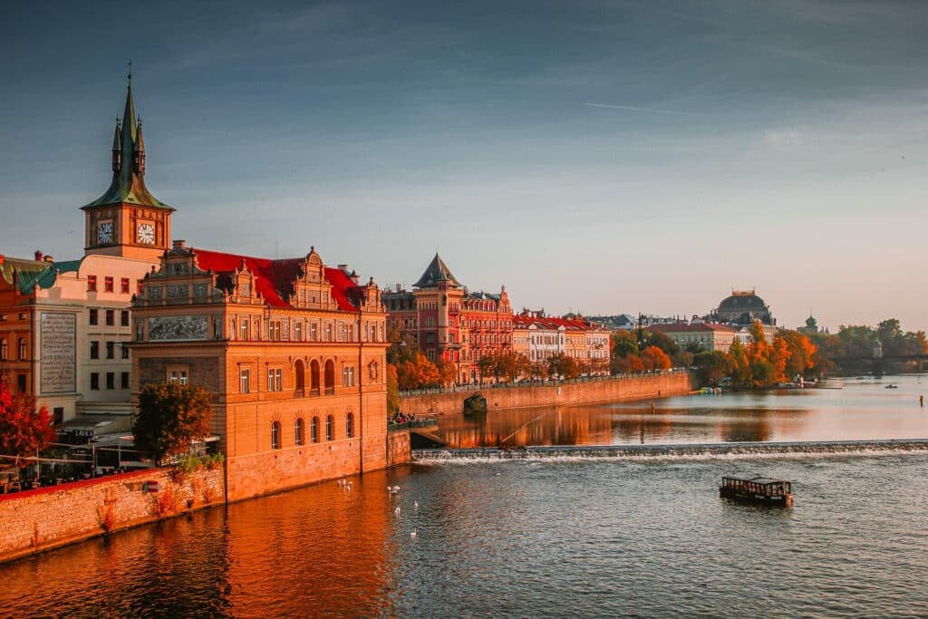 Vista do Charles Bridge, Praga, República Tcheca durante o dia com rio à frente com um barco navegando e ao fundo a cidade. Representa chip celular República Tcheca.
