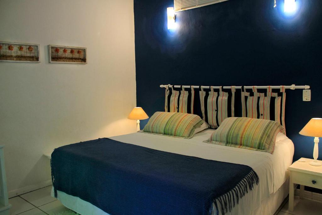 Quarto do Canto do Camburi com cama de casal no centro do quarto, duas cômodas com luminárias.