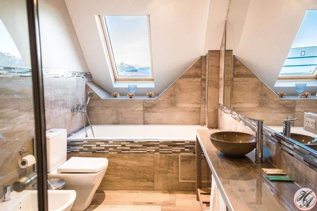 banheiro do Hosteria y Restaurante America com uma banheira, uma claraboia no teto e uma pia de pedra no canto direito