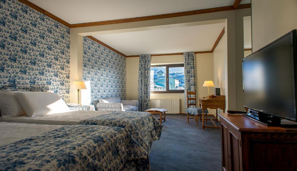 suíte do Las Hayas Ushuaia Resort com uma cama de casal, uma pequena sala de estar e uma pequena janela ao fundo