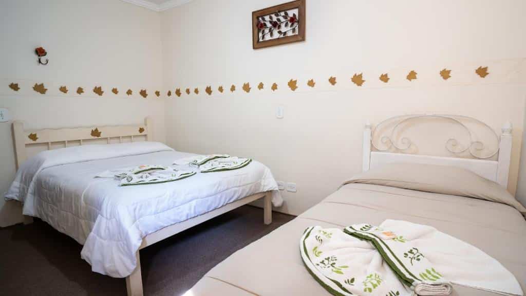Quarto da Pousada Araucária com uma cama de casal e uma de solteiro, para representar pousadas baratas em Campos do Jordão