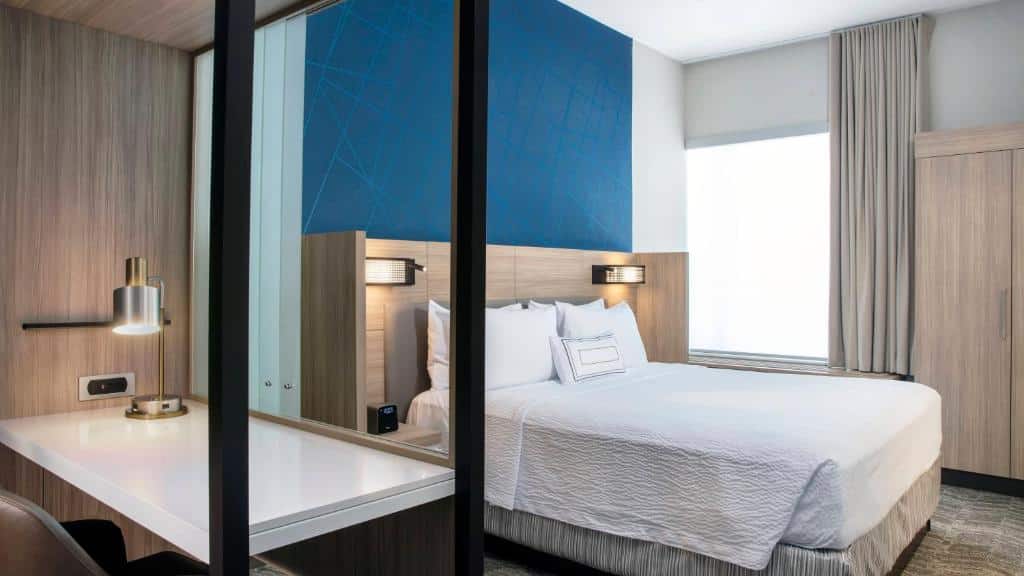 Quarto do SpringHill Suites by Marriott  com cama de casal no centro do quarto, do lado direito mesa de trabalho.