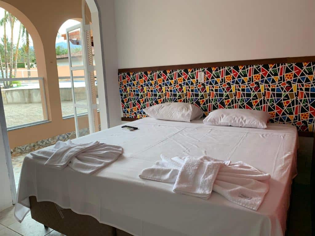 Quarto da Viva Barê Pousada com cama de casal e toalhas em cima da cama.