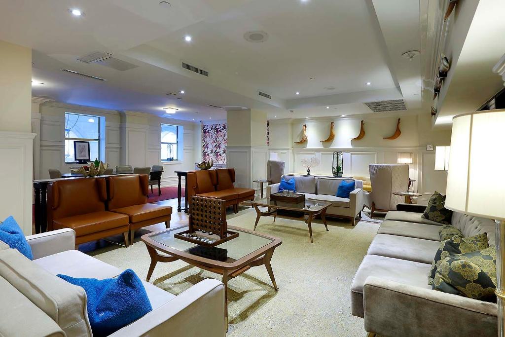 Vista da sala de estar do Eurostars Langford com sofás e poltronas em volta da sala com mesas de centro no meio. Representa hotéis em Miami.