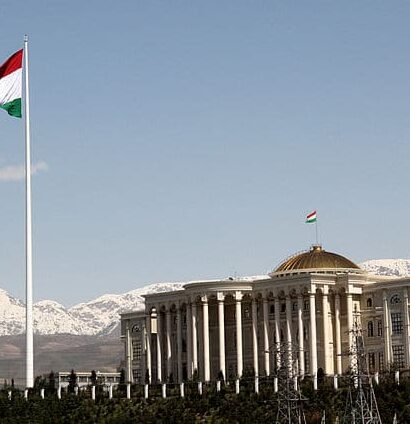 Vista do Palácio Presidencial das Nações, Dushanbe no Tajiquistão durante o dia com bandeira do país no mastro e o palácio ao lado direito. Representa chip celular Tajiquistão.