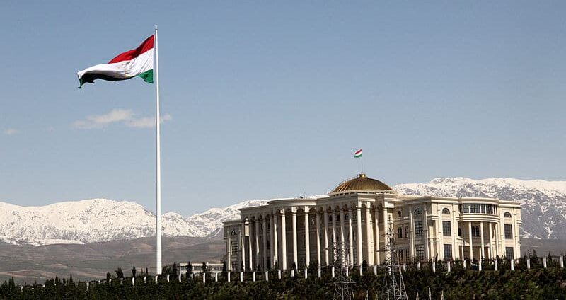 Vista do Palácio Presidencial das Nações, Dushanbe no Tajiquistão durante o dia com bandeira do país no mastro e o palácio ao lado direito. Representa chip celular Tajiquistão.