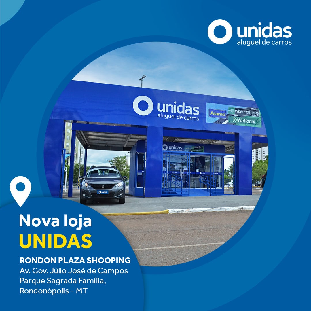 Nova loja Unidas Rent a Car em Rondonópolis (MT), com fachada azul e carro saindo do estacionamento da locadora, em dia de céu claro e com rua vazia à frente