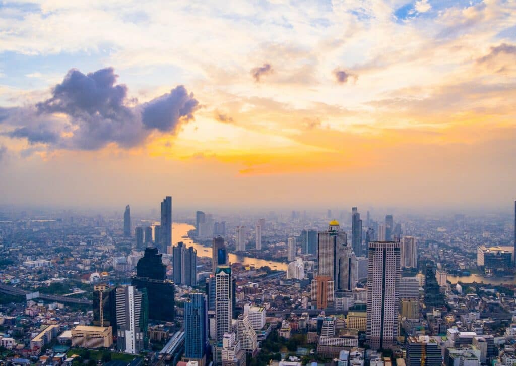 Vista aérea de Bangkok, com poucos prédios, um rio extenso cortando a cidade ao meio e poucas árvores pelas ruas, para representar chip celular Bangkok