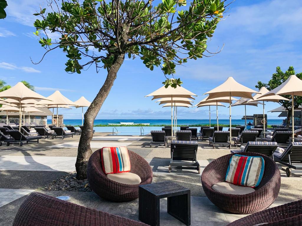 Vista da área de laser do InterContinental Fiji Golf Resort & Spa com cadeiras e guarda-sóis. Representa hotéis em Fiji.