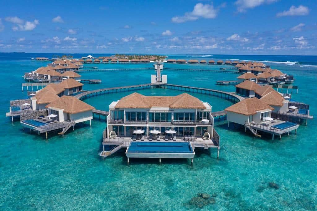 bangalôs do Radisson Blu Resort Maldives, um dos resorts nas Maldivas iguais organizados em formas arredondadas e bem completas com com diversos quartos, piscina privativa e escada que desce para o mar